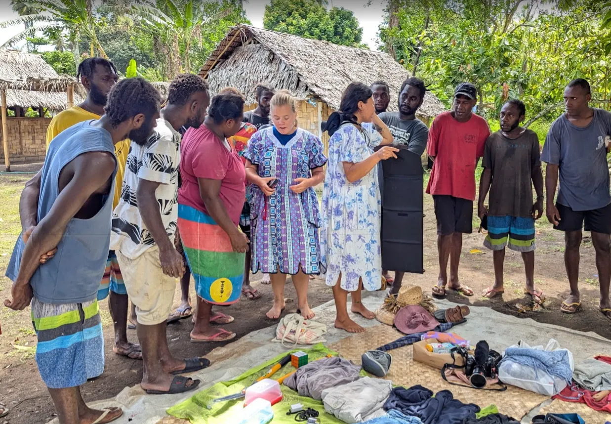 Crew and Banam Bay villagers laying out goods on mats for the trading day