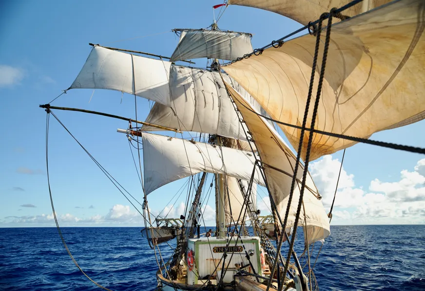 Crew rigging a temporary stunsail boom from a giant bamboo pole picked up in Banam Bay