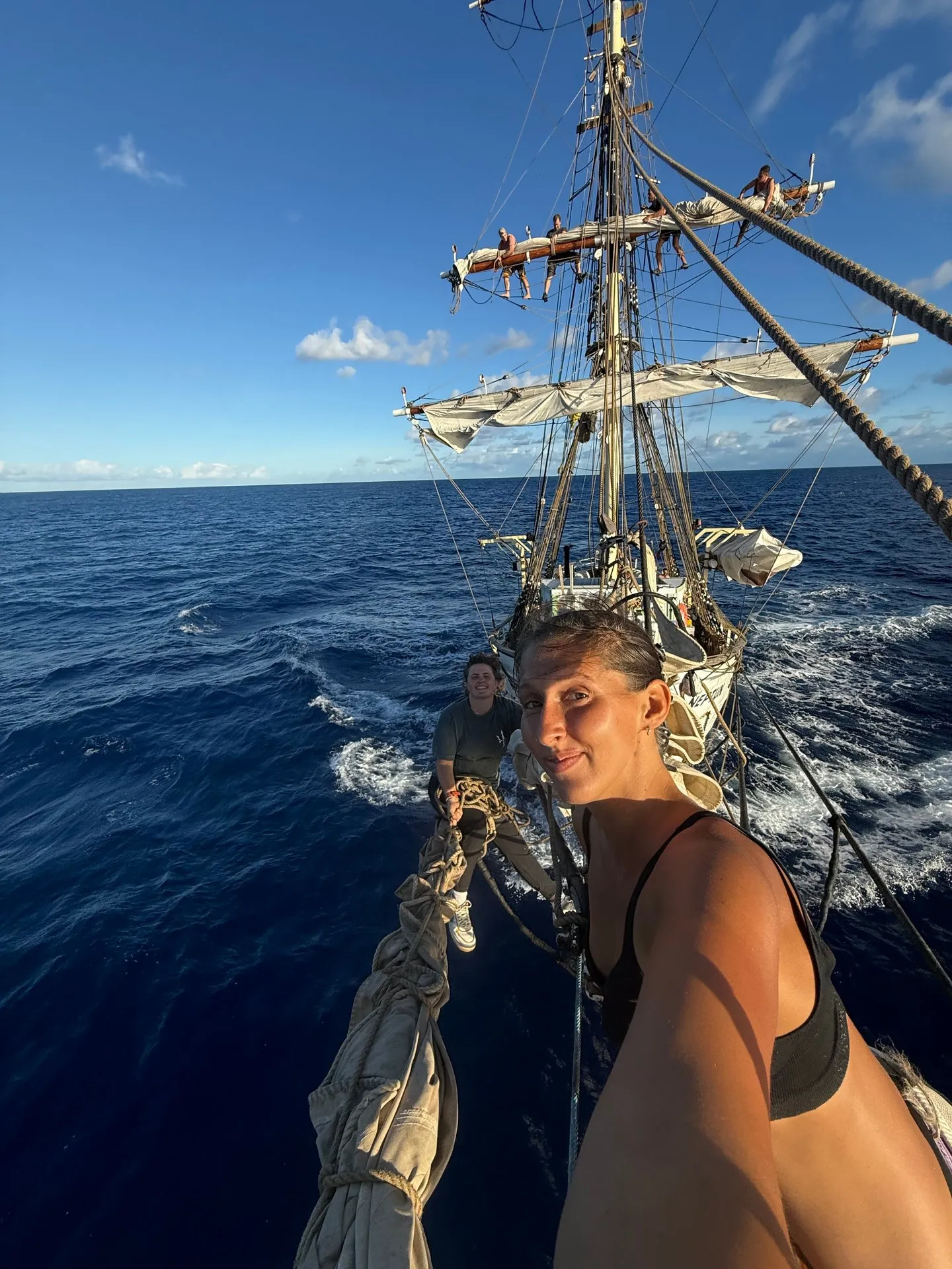 NEPTUN's crew out on the bowsprit under sail, with the ship's rig and the Indian Ocean behind