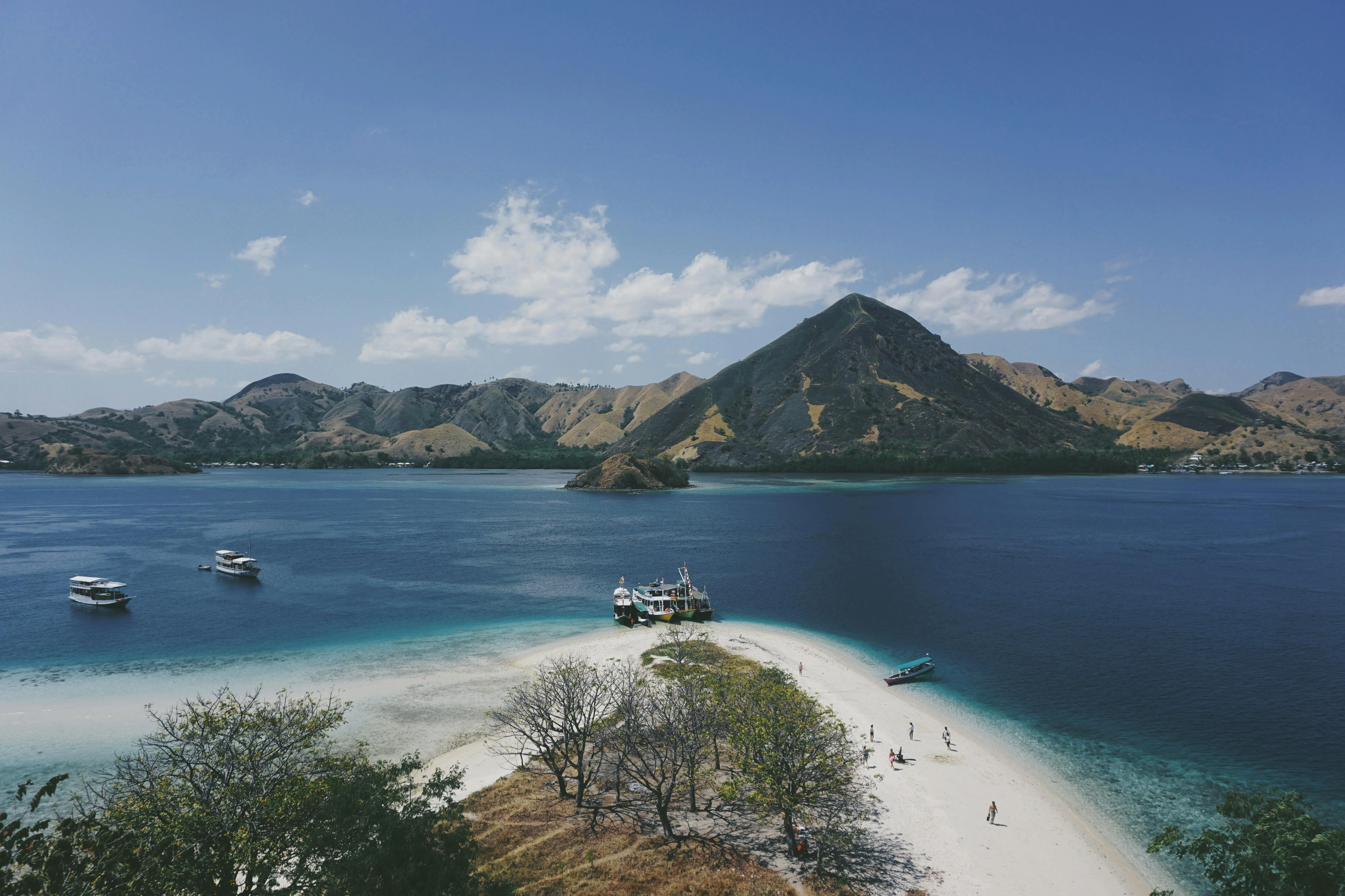 Aerial view of the Komodo archipelago, bone-dry savannah islands ringed by turquoise.