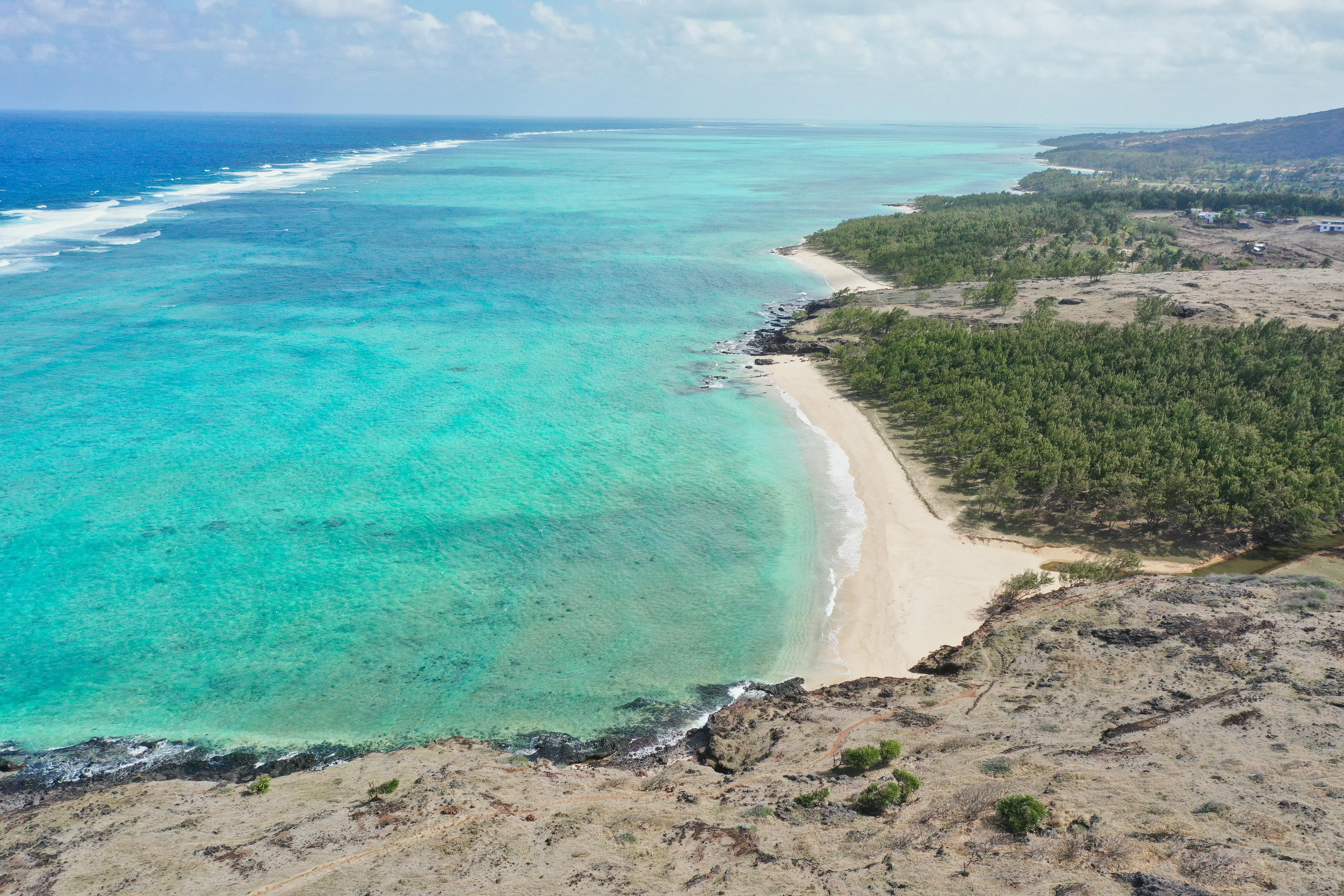 Rodrigues' coastline from the air, a volcanic spine wrapped in lagoon-blue.