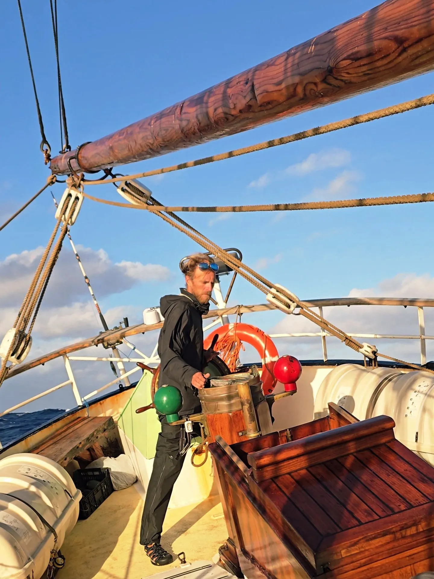 A crew member at NEPTUN's helm in the low evening sun